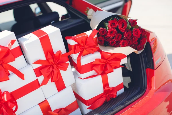 Geschenkboxen im Gepäckträger des roten Autos — Stockfoto