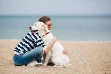 Young woman with a dog on a deserted beach
