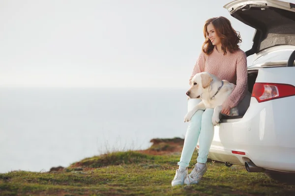 Girl on the beach with a white labrador and white car — Stock Photo, Image