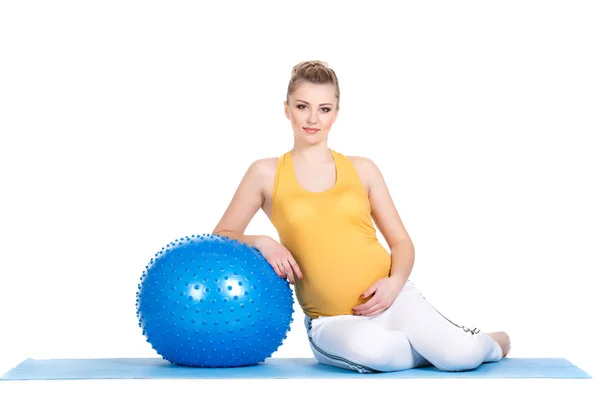 Una mujer embarazada hace gimnasia con pelota — Foto de Stock