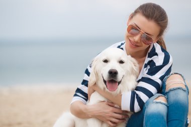 Young woman with a dog on a deserted beach
