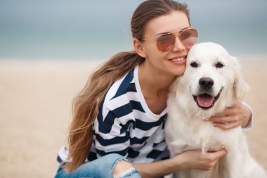 Young woman with a dog on a deserted beach