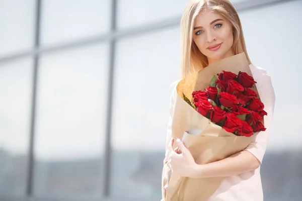 Bir genç gülümseyen güzel kadın portre çiçekler ile — Stok fotoğraf