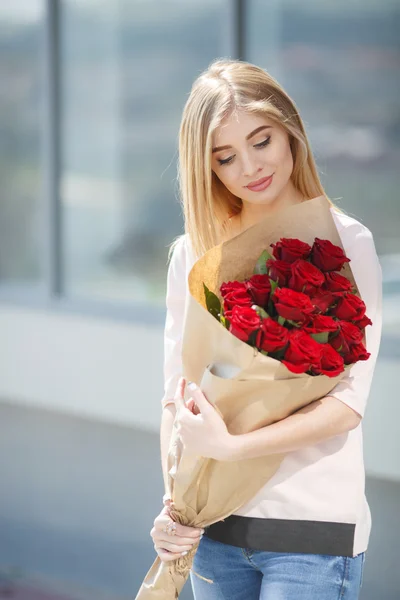 Porträtt av unga leende vacker kvinna med blommor — Stockfoto