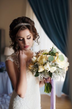 Bir buket çiçekli gelinlik içinde güzel bir gelin.
