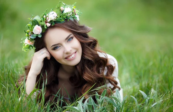 Spring portrait of a beautiful woman in a wreath of flowers — Stock Photo, Image