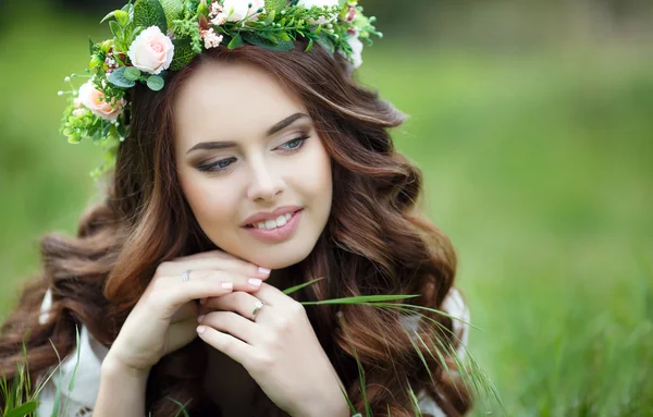 Våren porträtt av en vacker kvinna i en krans av blommor — Stockfoto