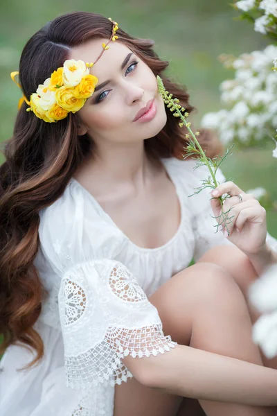 Våren porträtt av en vacker kvinna i en krans av blommor — Stockfoto