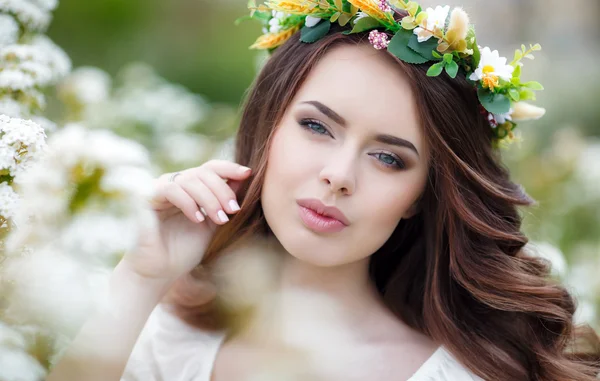 Våren porträtt av en vacker kvinna i en krans av blommor — Stockfoto