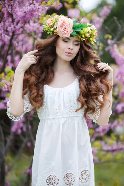 Retrato de primavera de una hermosa mujer en una corona de flores — Foto de Stock