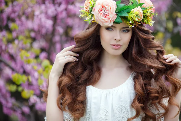 Retrato de primavera de una hermosa mujer en una corona de flores — Foto de Stock