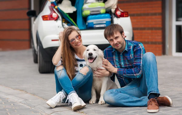 Muž a žena s psím autem připravené na výlet autem — Stock fotografie