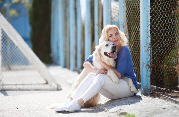 Retrato de uma mulher com belo cão brincando ao ar livre . — Fotografia de Stock