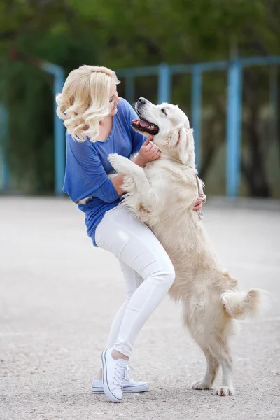 Porträtt av en kvinna med vacker hund leker utomhus. — Stockfoto