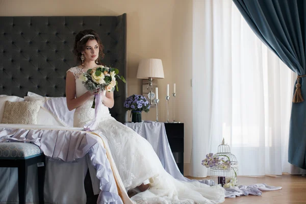 Hermosa novia en vestido de novia con ramo de flores — Foto de Stock