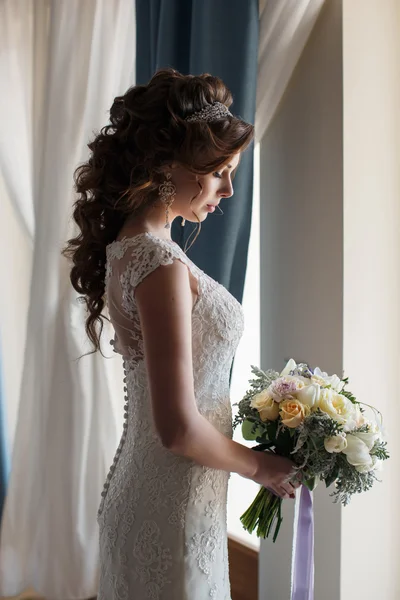 Piękna panna młoda w sukni ślubnej z bukietem kwiatów — Zdjęcie stockowe