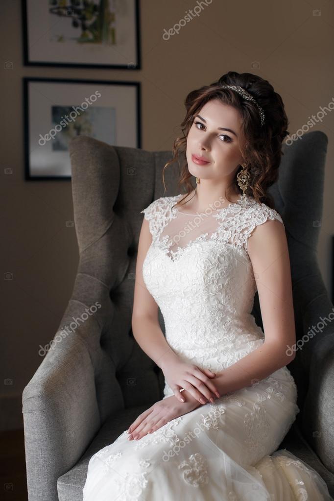 ホテルの部屋で椅子に座っているウェディング ドレスの美しい花嫁 ストック写真 C Golyak