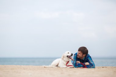Sahilde bir köpek ile genç bir adamın Bahar portre