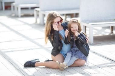 Zarif şekilde anne ve kızı ilkbaharda sokakta giyinmiş