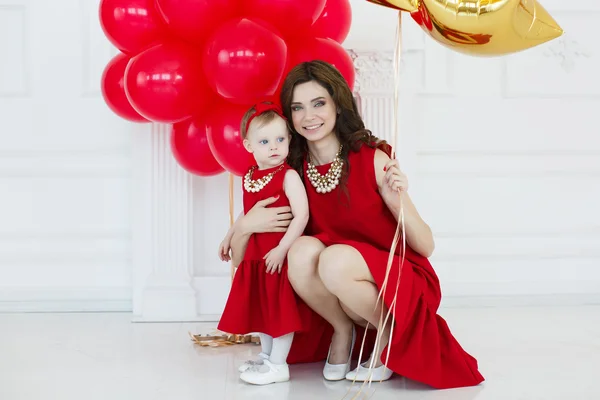 Studio portret van een moeder en haar dochter met ballonnen — Stockfoto