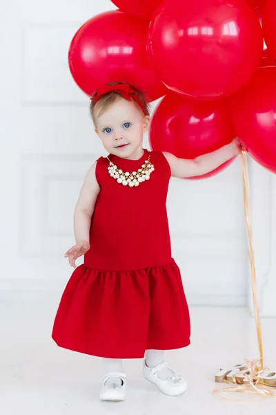 Happy child holding bunch of air balloons — Stock Photo, Image