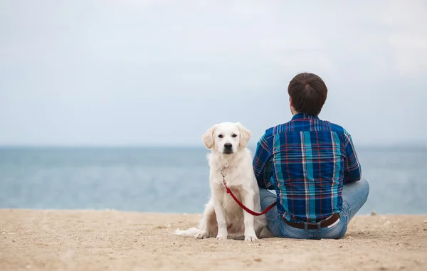 Mann mit Hund am Sommerstrand vor laufender Kamera — Stockfoto