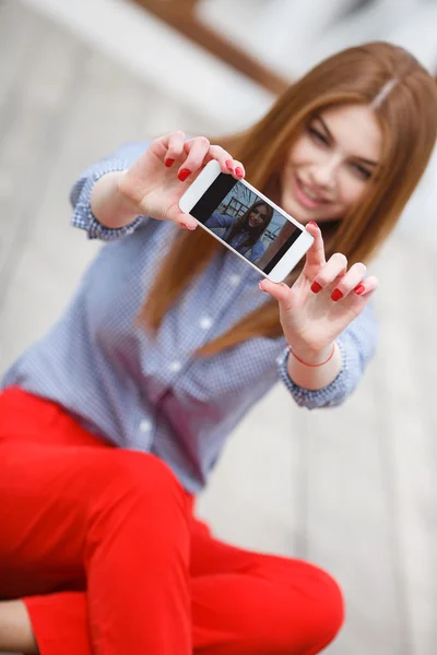 Beautiful young funky woman making selfie while sitting outdoors — Stok fotoğraf