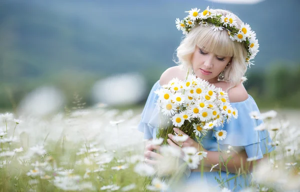 Pregnant woman in a field of blooming white daisies — Stock Photo, Image