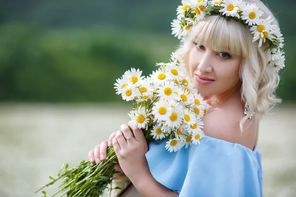 Pregnant woman in a field of blooming white daisies — Stock Photo, Image