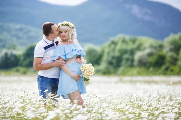 Casal feliz em um prado entre as flores — Fotografia de Stock