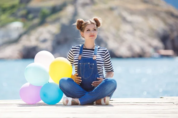 Gravid kvinna med färgglada ballonger på stranden — Stockfoto