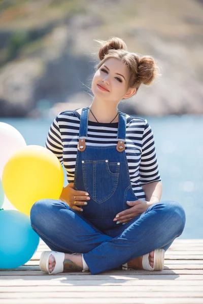 Gravid kvinna med färgglada ballonger på stranden — Stockfoto