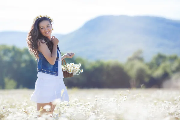 Молодая женщина с букетом белых маргариток на лугу — стоковое фото