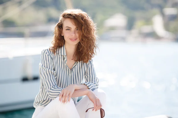Beautiful girl on the pier next to the yacht club — Stock Photo, Image