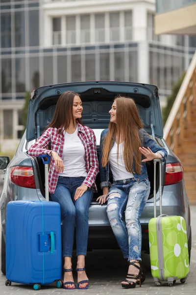 Two girlfriends with the bags near the car — Stock Photo, Image