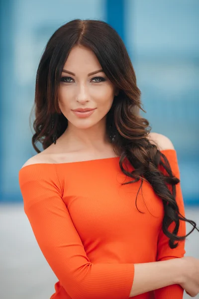 Pretty woman with brown eyes posing on a background of the city. — Stock Photo, Image