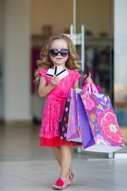 Süpermarkette alışveriş için renkli çanta ile sevimli küçük kız