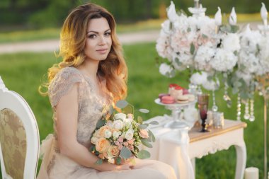 Gelin buketi yaz bahçesinde mutlu gelin