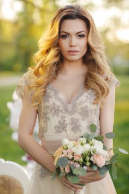 Gelin buketi yaz bahçesinde mutlu gelin