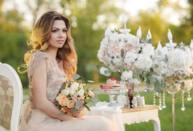 Gelin buketi yaz bahçesinde mutlu gelin