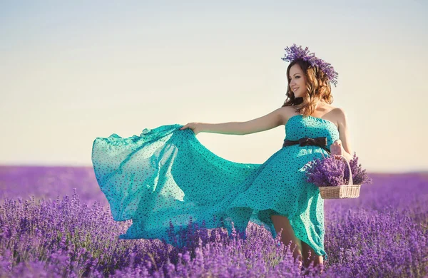 Schwangere in türkisfarbenem Kleid auf Lavendelfeld — Stockfoto