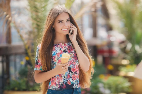 Летний портрет девушки с мороженым, разговаривающей по телефону — стоковое фото