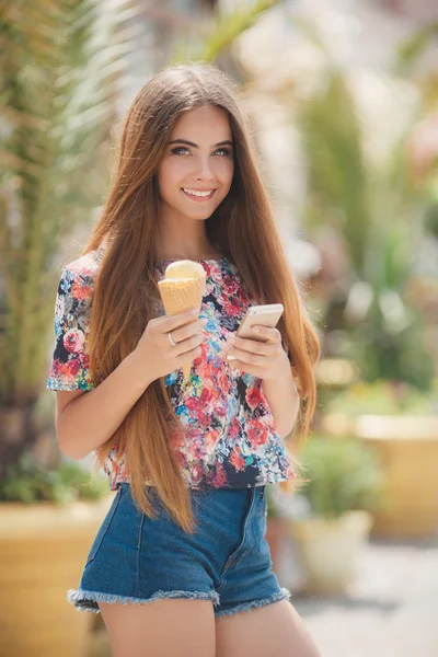 Gyönyörű lány fagylalttal olvasás üzenet a mobiltelefonon — Stock Fotó