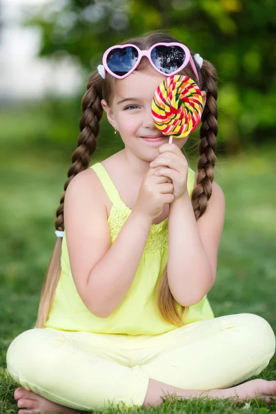 Söt liten flicka med stora färgglada Lollipop. — Stockfoto