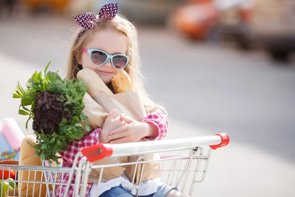 Ребенок сидит в корзине с едой возле торгового центра . — стоковое фото