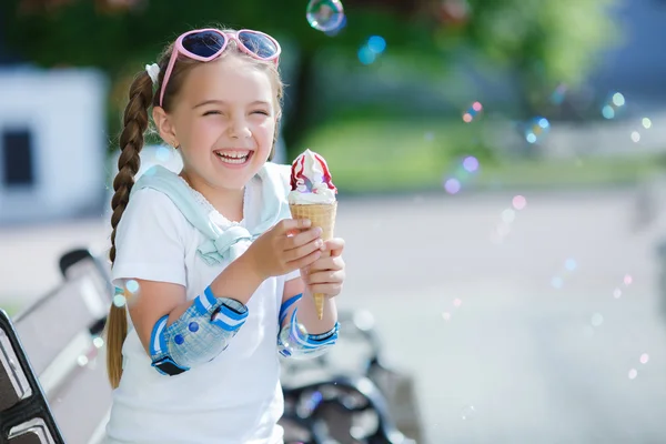 Glad liten flicka i parken med glass kon — Stockfoto