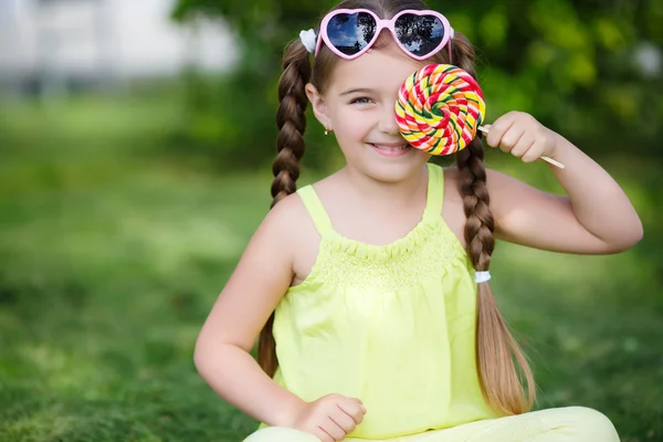 Linda niña con gran piruleta de colores . —  Fotos de Stock