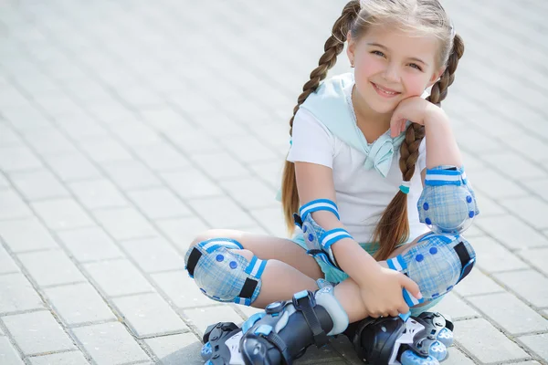 Petite fille sur patins à roulettes dans le parc . — Photo