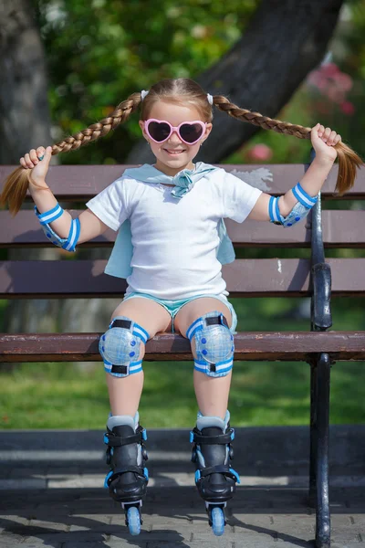 Holčička na kolečkových bruslích v parku. — Stock fotografie