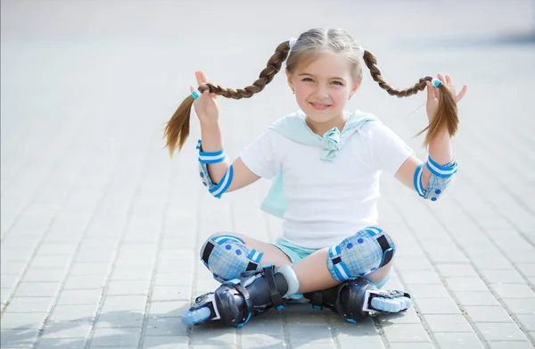 Kleines Mädchen auf Rollschuhen im Park. — Stockfoto